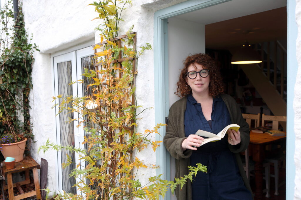 Woman standing in doorway holding a book