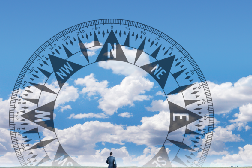man walking towards a compass overlayed on the sky;
